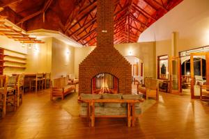 a fireplace in a room with a table and chairs at Chui hidden Lodge Karatu in Karatu