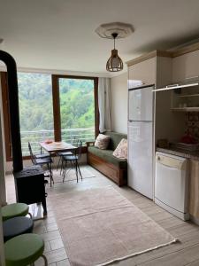 a kitchen with a couch and a table with a view at Komilo Homes - Functional Modern Suite in Çamlıhemşin