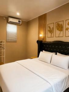 a bedroom with a large bed with white sheets at Bali Queen Cottage in Pabean Buleleng +3 photos