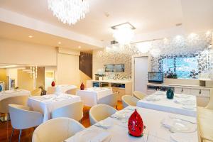 a dining room with white tables and white chairs at Relais Paradiso in Vietri sul Mare