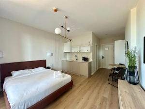 a bedroom with a bed and a table and a kitchen at Nova Concierge Aparthotel in Batumi +41 photos