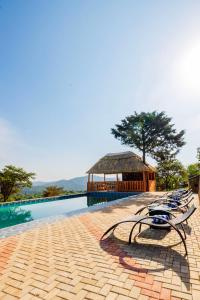 a group of chairs sitting next to a swimming pool at Chui hidden Lodge Karatu in Karatu