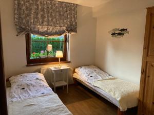 two beds in a small room with a window at Apartamenty Rogowscy - Apartamenty na wynajem w Rewalu in Rewal