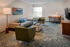 a living room with a couch and a desk at SpringHill Suites by Marriott Buffalo Airport in Williamsville