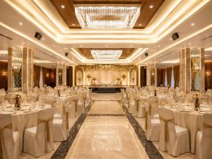 a banquet hall with white tables and chairs at The Crown Puducherry in Pondicherry
