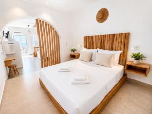a bedroom with a large bed with two towels on it at Thea Suites Naxos in Agios Prokopios +83 photos