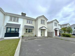 a large white house with a parking lot at An Tulan Cleasach Spiddal in Spiddal