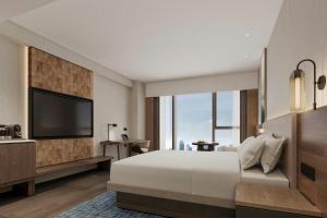 a bedroom with a large bed and a flat screen tv at Fairfield by Marriott Kunming Xishan in Kunming +17 photos