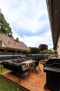 a deck with couches and a table and a piano at LUMEA Devin in Stralsund