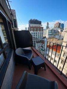 a balcony with a chair and stool on a building at El Misti Suites Buenos Aires in Buenos Aires