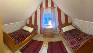 two beds in a room with red and white stripes at Siedlisko Urszulanka Dom in Policzna