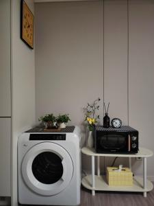 a kitchen with a washing machine and a microwave at 히얼마리나 in Ungch'ŏn-ni