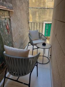 a patio with two chairs and a table on a balcony at Bonaca Residence in Makarska