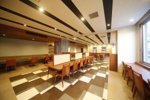 a dining room with tables and chairs and a checkered floor at Dormy Inn Kochi in Kochi