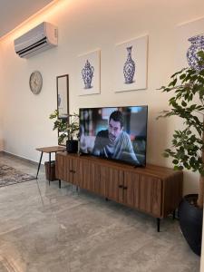 a flat screen tv sitting on top of a wooden entertainment center at وحده خاصة بمدخل مباشر s1 in Al Kharj