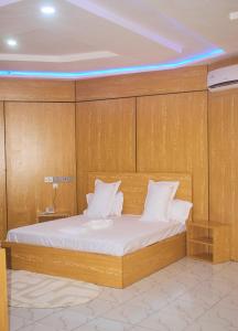 a bed in a room with a wooden wall at Hotel St Flavien Lomé in Taméklo