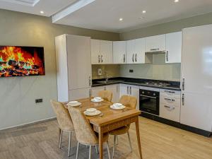 a kitchen with a wooden table and chairs at Dominium Residence in Agadir