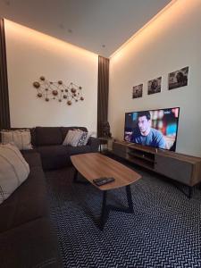 a living room with a couch and a flat screen tv at وحده خاصة بمدخل مباشر s1 in Al Kharj +9 photos