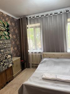 a bedroom with a bed and a window at Shabdan Guest House in Toktogul