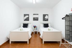 two beds in a room with white walls at Vv Casa Marire in Breña Alta