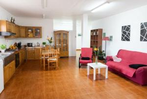 a living room with a red couch and a kitchen at Vv Casa Marire in Breña Alta