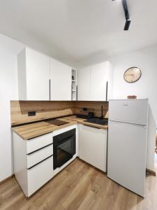 a white kitchen with white cabinets and a refrigerator at Casa Mare in Prčanj