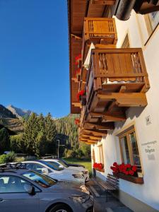 a building with cars parked in a parking lot at Gästehaus WOLFGARTEN in Sankt Jakob in Defereggen