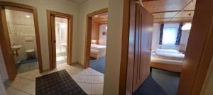 a room with two beds and a bathroom at Gästehaus WOLFGARTEN in Sankt Jakob in Defereggen