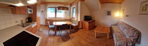 a living room with a kitchen and a table at Gästehaus WOLFGARTEN in Sankt Jakob in Defereggen
