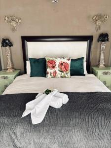 a bedroom with a bed with towels on it at La Grace Guestrooms in Kroonstad
