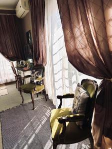 a living room with two chairs and a window at La Grace Guestrooms in Kroonstad