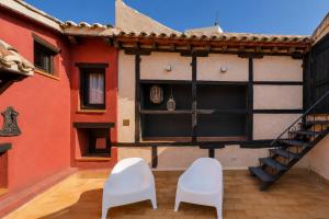 two white chairs sitting on the outside of a building at Apartamento La Contessina, junto a la Catedral in Toledo