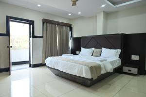 a bedroom with a large bed and a large window at Kamath Yatri Nivas Plus in Māvalli