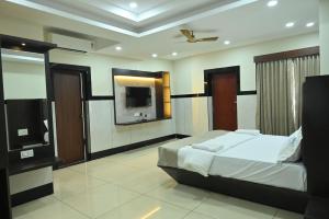 a bedroom with a bed and a flat screen tv at Kamath Yatri Nivas Plus in Māvalli +31 photos