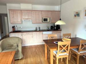 a kitchen with wooden cabinets and a table and chairs at Stranach Appartements in Sankt Michael im Lungau