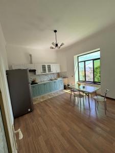 a kitchen and dining room with a table and chairs at Gunluk ev in Sheki