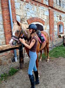 a woman is standing next to a horse at Maringotka Vojenského Stylu na Šumavě in Bošice