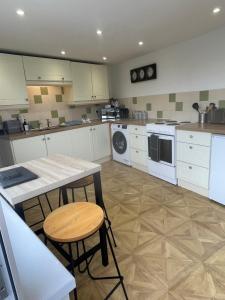a kitchen with white appliances and a table and chairs at Bryndegwel in Saint Dogmaels, cardigan- river views, Free parking in Cardigan