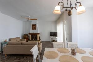 a living room with a couch and a table and chairs at house las chuchas CALAHONDA in Motril