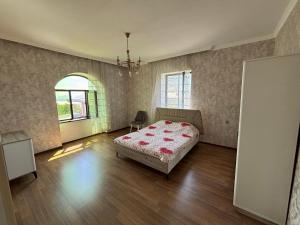 a bedroom with a bed and a window in it at Gunluk ev in Sheki