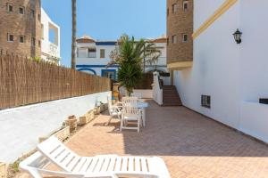 a patio with white lounge chairs and a table at house las chuchas CALAHONDA in Motril
