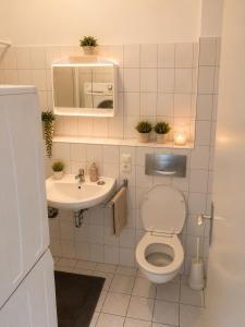 a small bathroom with a toilet and a sink at Central Rooms Hauptbahnhof Koblenz in Koblenz