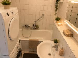 a bathroom with a sink and a washing machine at Central Rooms Hauptbahnhof Koblenz in Koblenz