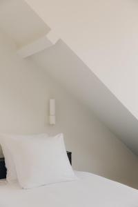 une chambre avec un lit blanc et un plafond blanc dans l'établissement ROMY BRUGES Historic Centre, à Bruges