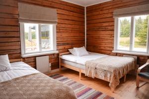a bedroom with two beds and two windows at Villa Onni in Kauhajoki