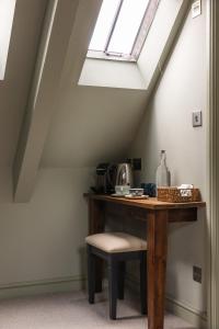 a wooden table with a chair and a window at The Bell & Stuart House in Stow on the Wold