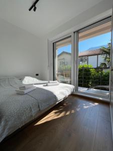 a white bedroom with a bed and a large window at Casa Mare in Prčanj