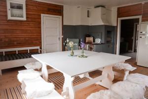 a white dining room with a white table and chairs at Villa Onni in Kauhajoki
