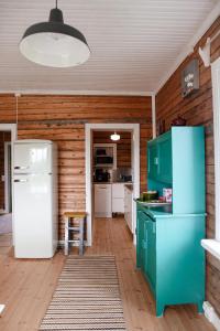 a kitchen with green cabinets and a white refrigerator at Villa Onni in Kauhajoki +15 photos