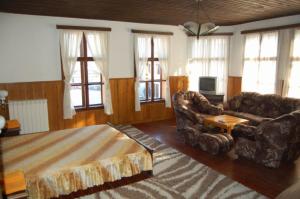 a bedroom with a bed and a couch and a tv at Trevnenski Kat Hotel in Tryavna